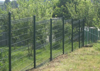 Klasična panelna providna ograda zelene boje postavljena stepenasto na zelenoj padini.